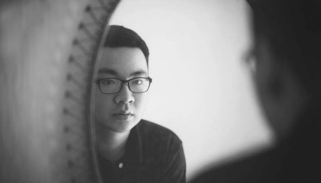 Young Asian man looking in the mirror