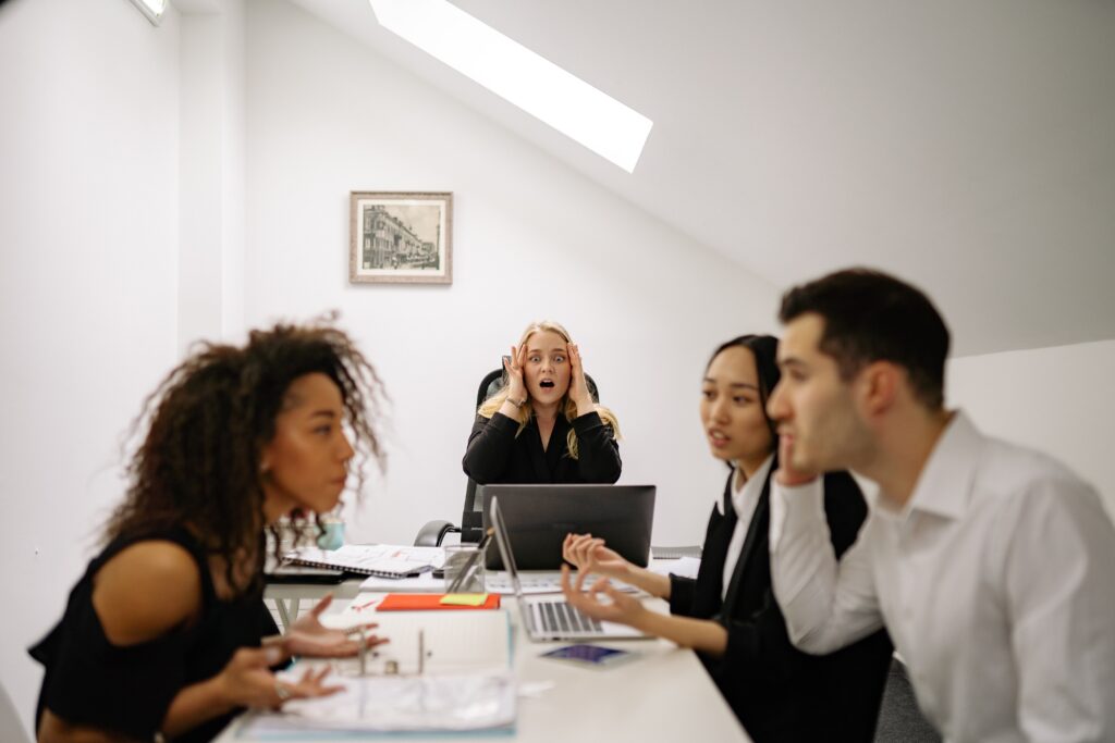 A woman wondering how to deal with difficult people as her co-workers are arguing