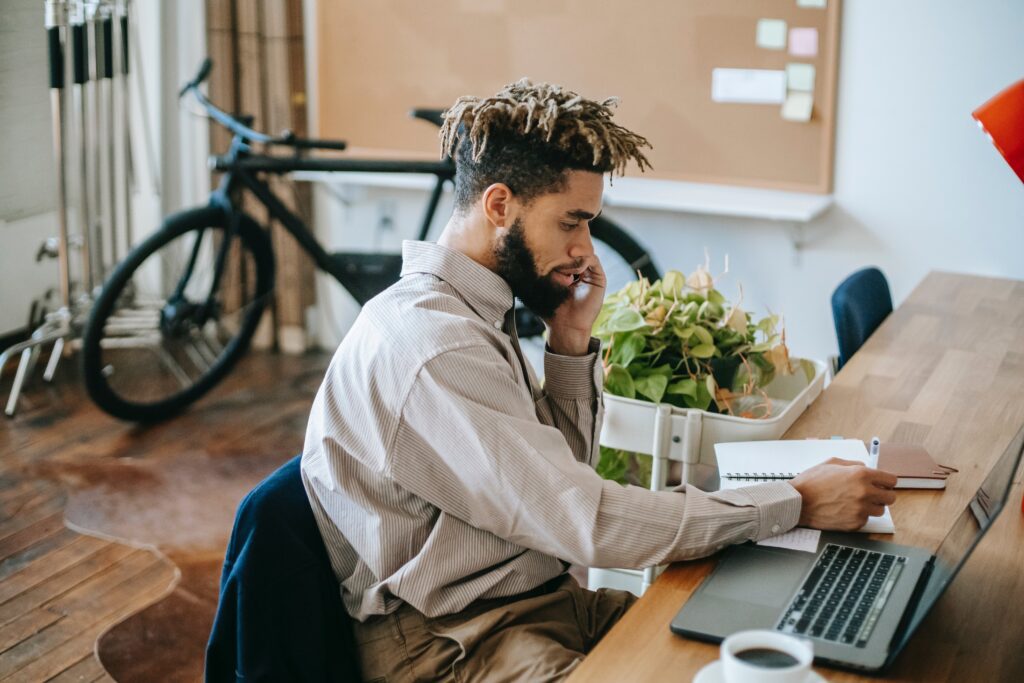 A Black man working to finish the year strong in his home office.
