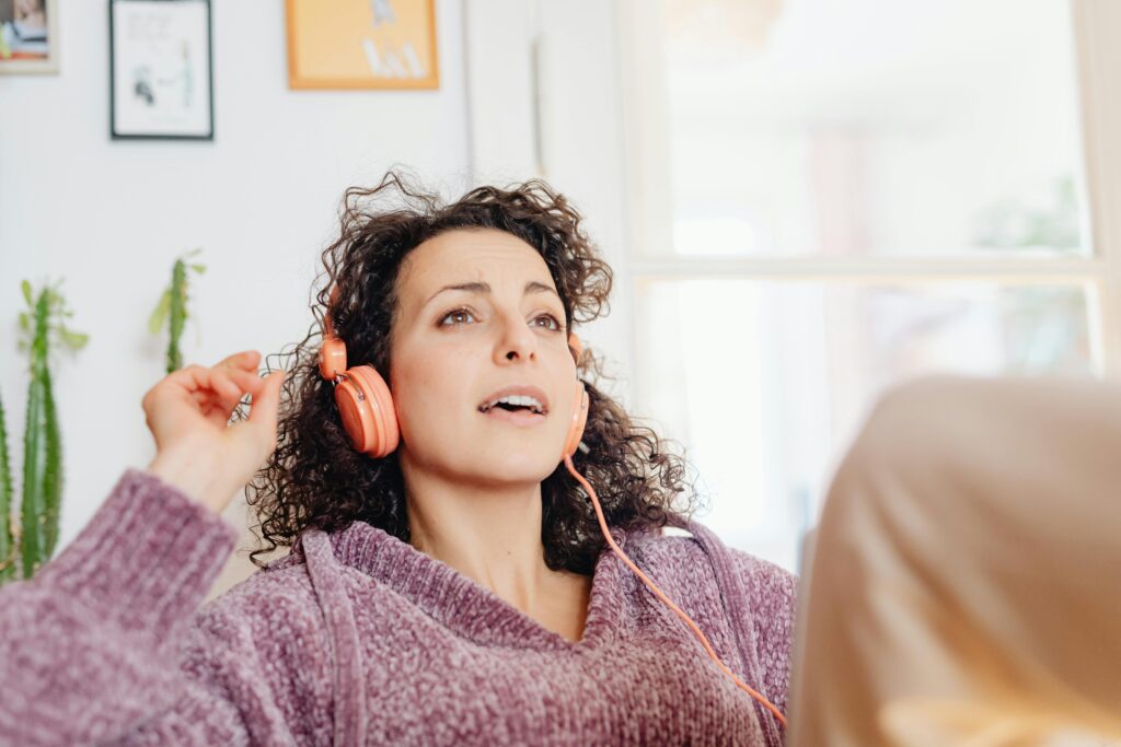 A woman sitting at home, listening to women empowerment songs.